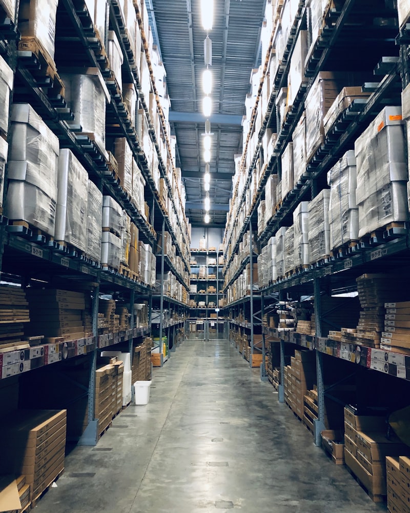 A tall warehouse aisle with racked pallets stretching to the ceiling